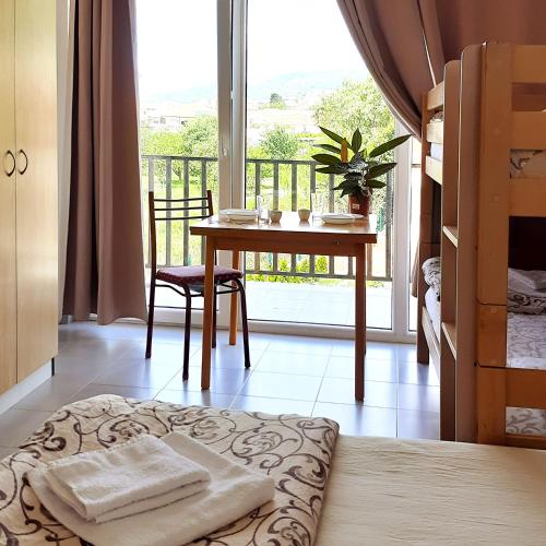 1 Schlafzimmer mit einem Tisch und einem Balkon mit Aussicht in der Unterkunft Apartments DEA in Bar