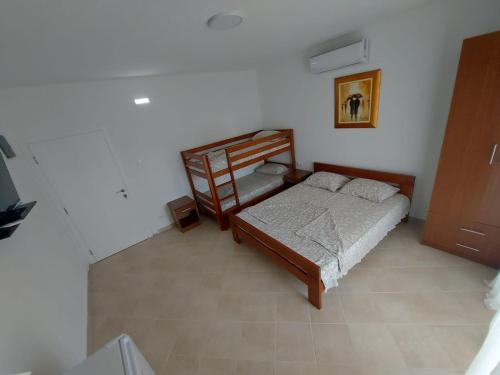 a bedroom with a bed and a chair in it at Apartmani Sunce in Bar