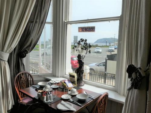 a dining room table with a view of a street at The Cumberland in Llandudno