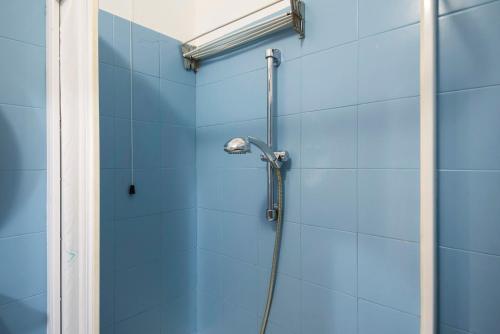 y baño con ducha y azulejos azules. en Appartamento Bilocale Moneglia 37, en Moneglia