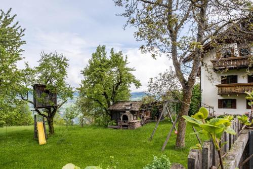 a yard with a house and a swing at Stablerhof Apt Löwenzahn in Cornedo all'Isarco