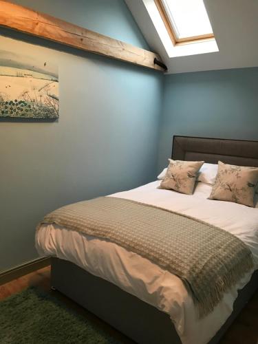 1 dormitorio con 1 cama en una pared azul en Escape To The Country, en Lincoln
