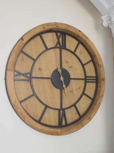 a wooden clock hanging on a wall at The Cumberland in Llandudno