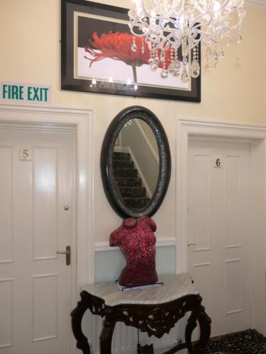 a vase sitting on a table in front of a mirror at The Cumberland in Llandudno
