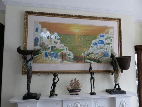 a painting on a wall with two statues on a shelf at The Cumberland in Llandudno