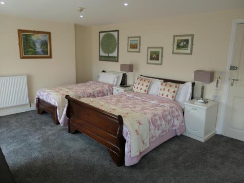 a bedroom with two beds and two lamps at The Cumberland in Llandudno