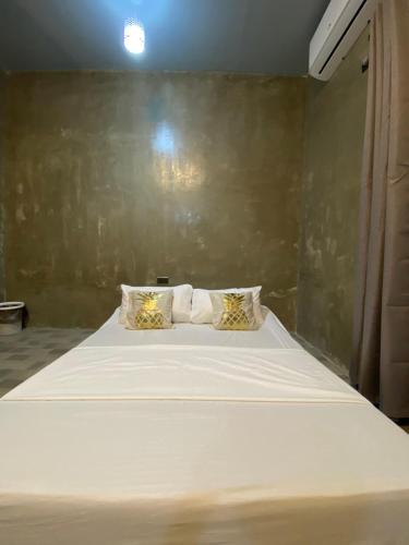 a bedroom with a large white bed with two pillows at Hai Inn in Dumaguete