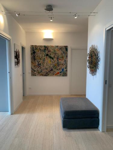 a room with a blue ottoman and a painting on the wall at Casa Nausica in Acitrezza