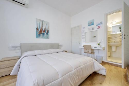 a white bedroom with a large bed and a sink at B&B Felicioni in Fiumicino