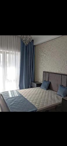 sypialnia z dużym łóżkiem z niebieską zasłoną w obiekcie Milaya kvartira w mieście Baku