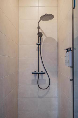 a shower with a shower head in a bathroom at Hotel St Joris I Kloeg Collection in Middelburg
