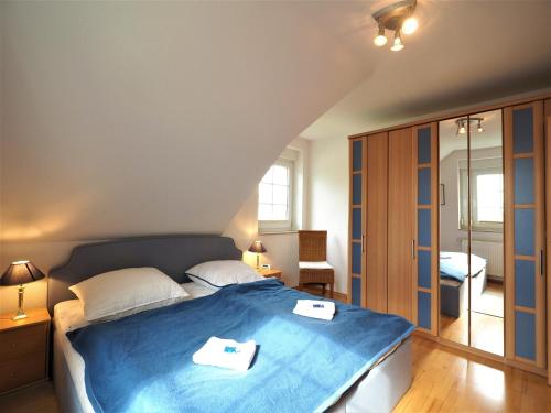 sypialnia z niebieskim łóżkiem i 2 ręcznikami w obiekcie Haus Regenbogen w Zingst