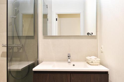 a bathroom with a sink and a shower at Miramar Residences - Luxurious Seaside Apartments in Blankenberge
