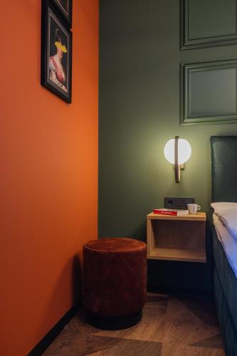 a bedroom with a bed and a table with a stool at Hotel St Joris I Kloeg Collection in Middelburg