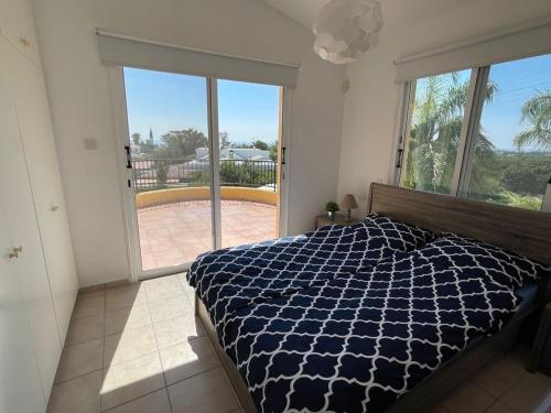 een slaapkamer met een bed en een groot raam bij Coral Bay new furnished private villa with pool in Peyia