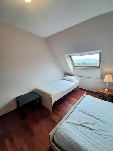 Cette petite chambre comprend 2 lits et une fenêtre. dans l'établissement Ático playa grande de Miño, à Miño