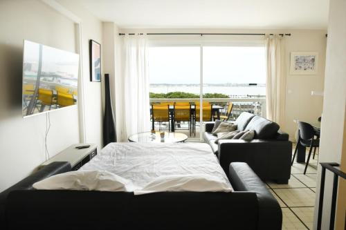 a living room with a bed and a couch at Duplex de 100m2 avec 3 chambres vue mer in Royan