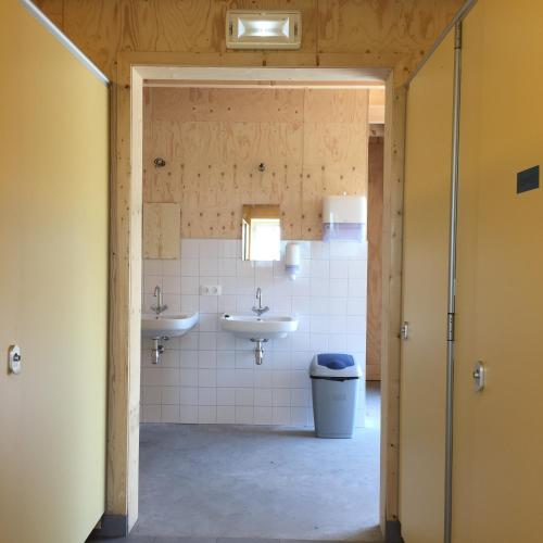 a bathroom with two sinks and a toilet at VierVaart Veldhuisje MOS in Groede