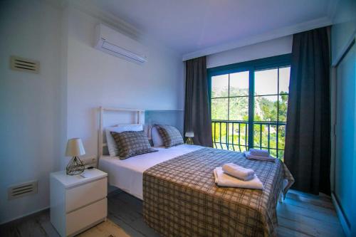 um quarto com uma cama e uma grande janela em DADYA VİLLA 4 - Marmaris Turgut da özel havuzlu denize yakın lüks villa em Marmaris