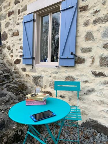 une table bleue, deux chaises et une fenêtre dans l'établissement Gîte Maison du Trottoir, Sussac, à Sussac