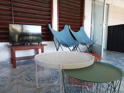 Habitación con mesa, 2 sillas y TV. en le moringa Appart vue mer 360 Mamoudzou hyper centre en Mamoudzou