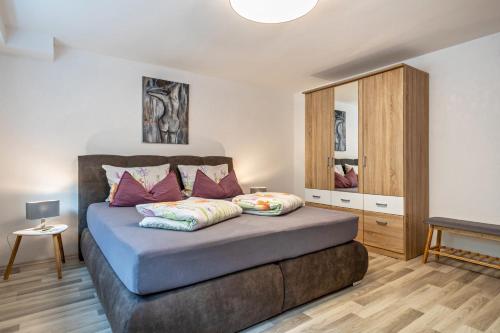 een slaapkamer met een bed met paarse kussens bij Helms in Eriskirch