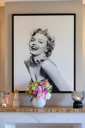 a framed picture of a woman with flowers on a shelf at La Bastide de Damien, 5 clefs Demeure d'Exception et Table Remarquable dans le guide Teritoria, JACUZZI Privatif, Cuisine étoilée Dominique Frérard in Aix-en-Provence
