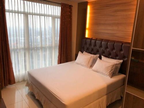 sypialnia z dużym łóżkiem i dużym oknem w obiekcie Central Park Apt. 3 Bedroom (42nd Floor - Alaina) w Dżakarcie