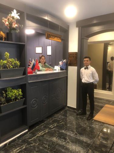 a man and a woman standing at a counter in a salon at Adora Hotel in Istanbul