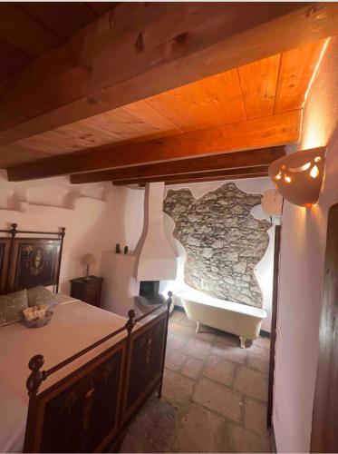 a bedroom with a bath tub with a stone wall at Corso 41 in Bosa