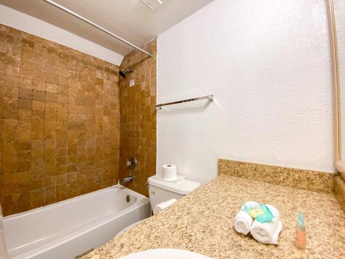 een badkamer met een wastafel, een toilet en een bad bij Universal Family Fun Perfectly Located + amenities in Orlando