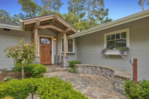 a house with a stone walkway leading to a wooden door at 3835 Molly's Cove home in Pebble Beach