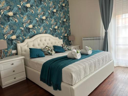 a bedroom with a bed with a floral wallpaper at Anema & Core Home in Porto SantʼElpidio