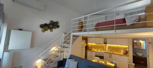 un salon avec un escalier menant à une mezzanine dans l'établissement Spata center loft, à Spáta