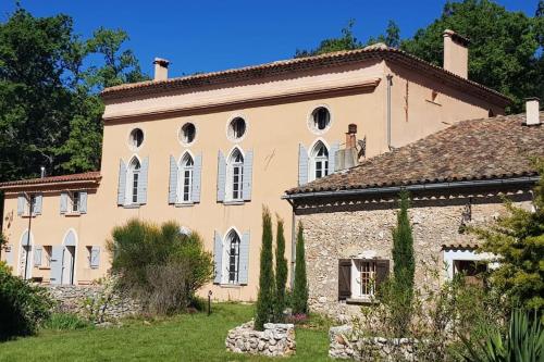 Cette ancienne maison en pierre possède des fenêtres et une cour. dans l'établissement La Bastide Basse Nature Piscine à 3 quarts d'heure de la mer, à Signes