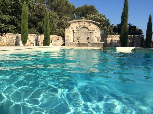 a swimming pool in a garden with blue water at Domaine de la Bastide Basse in Signes