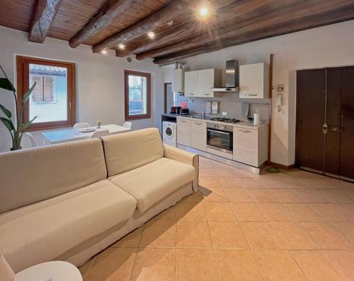sala de estar con sofá y cocina en Pao Apartment - Castelvecchio, en Verona