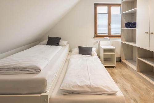 two beds in a small room with a window at Über der alten Gärtnerei in Allensbach