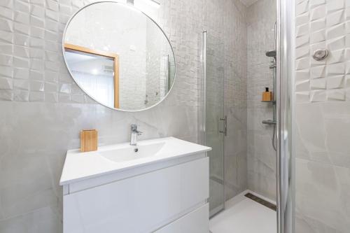 een witte badkamer met een wastafel en een spiegel bij Villa Doris in Zaton