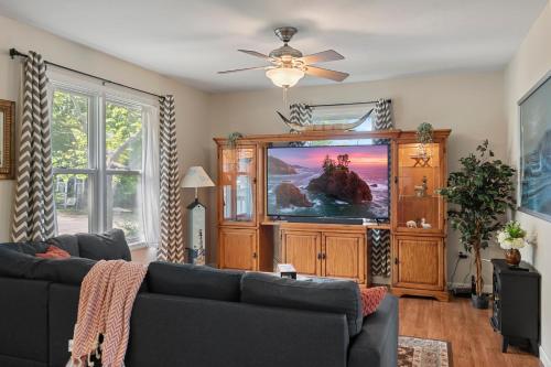 ein Wohnzimmer mit einem Sofa und einem Flachbild-TV in der Unterkunft Modern Bungalow Home with Mid-Century Flair in Springfield