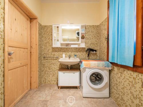 a bathroom with a sink and a washing machine at Casa Ida in Putzu Idu