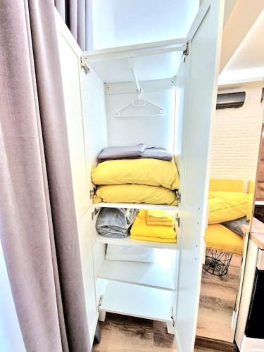 a white closet with yellow towels and a curtain at The Little Prince studio in Varna City