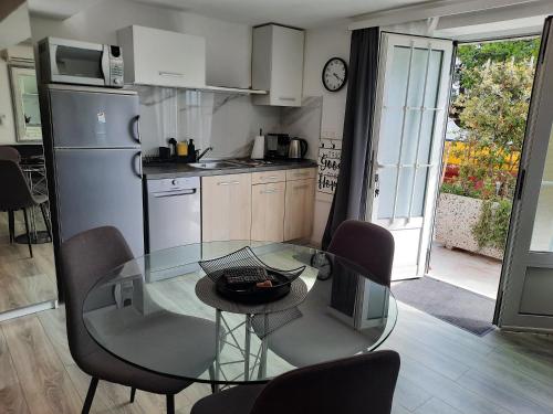 a small kitchen with a glass table and chairs at Apartments Anita in Crikvenica