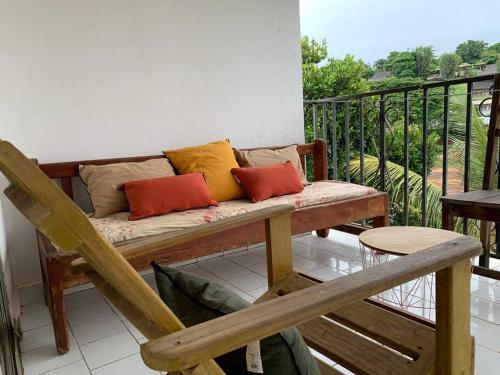 a bench sitting on a balcony with pillows on it at studio cocoon perche 119 Mdz in Mamoudzou