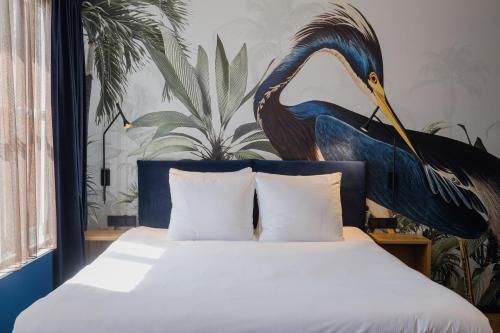 a bedroom with a bed with a bird on the wall at Hotel St Joris I Kloeg Collection in Middelburg