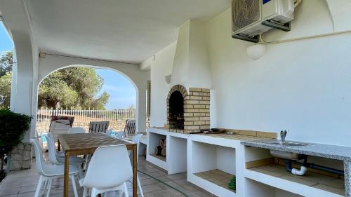 a kitchen with a table and chairs and a fireplace at Falésia - Private Pool - 8 Guests - Albufeira in Albufeira