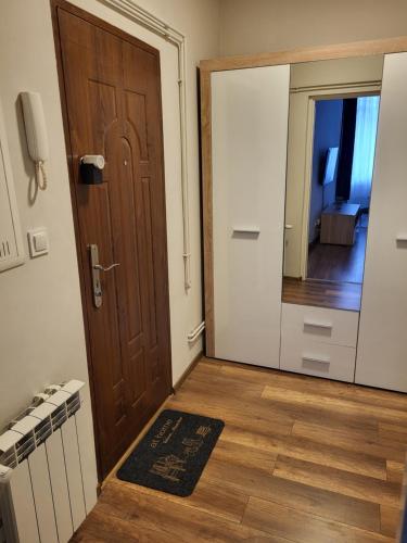pasillo con puerta de madera y espejo en Apartamenty Rynek K, en Przemyśl
