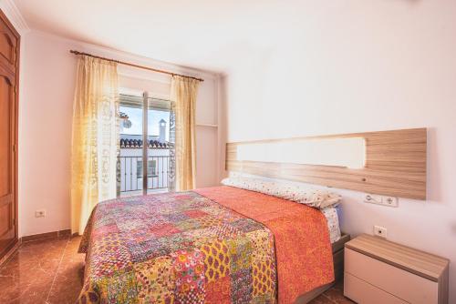 sypialnia z dużym łóżkiem i oknem w obiekcie Villa Zoe w mieście Nerja