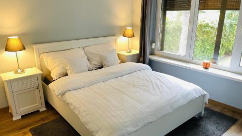 1 Schlafzimmer mit einem weißen Bett und 2 Fenstern in der Unterkunft Pod Świerkami in Boszkowo
