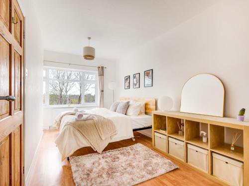 a white bedroom with a bed and a mirror at Pass the Keys Bright Spacious Home Away From Home With Parking in Abbey Wood